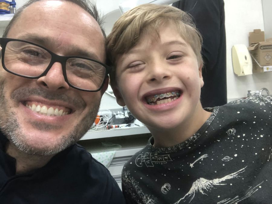 Paciente sorrindo com o Dr. Rogério Dal Bello no consultório